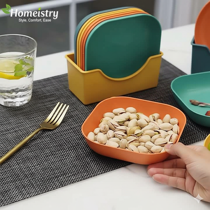 Colorful plates and a bowl with pistachios on a table with 'Homeistry' branding.