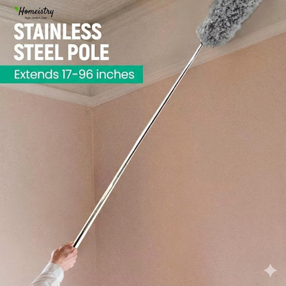 Stainless steel pole with a fluffy brush attachment, extending from a hand to the ceiling, against a beige wall.