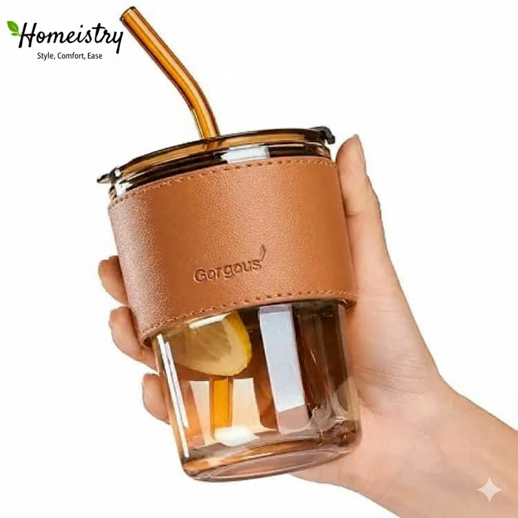 Hand holding a glass cup with a brown leather sleeve and straw, branded 'Gorgeous'.