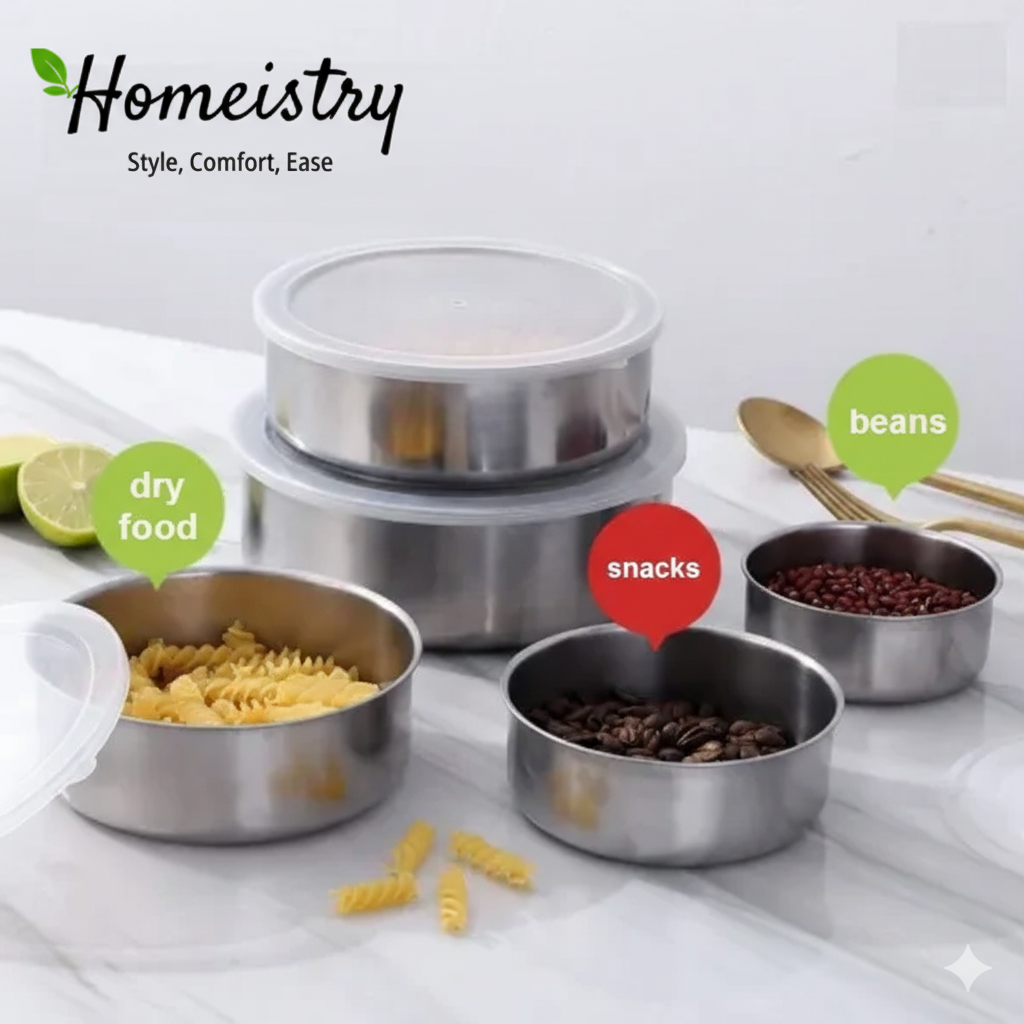 Set of stainless steel food containers with labeled contents on a white surface.